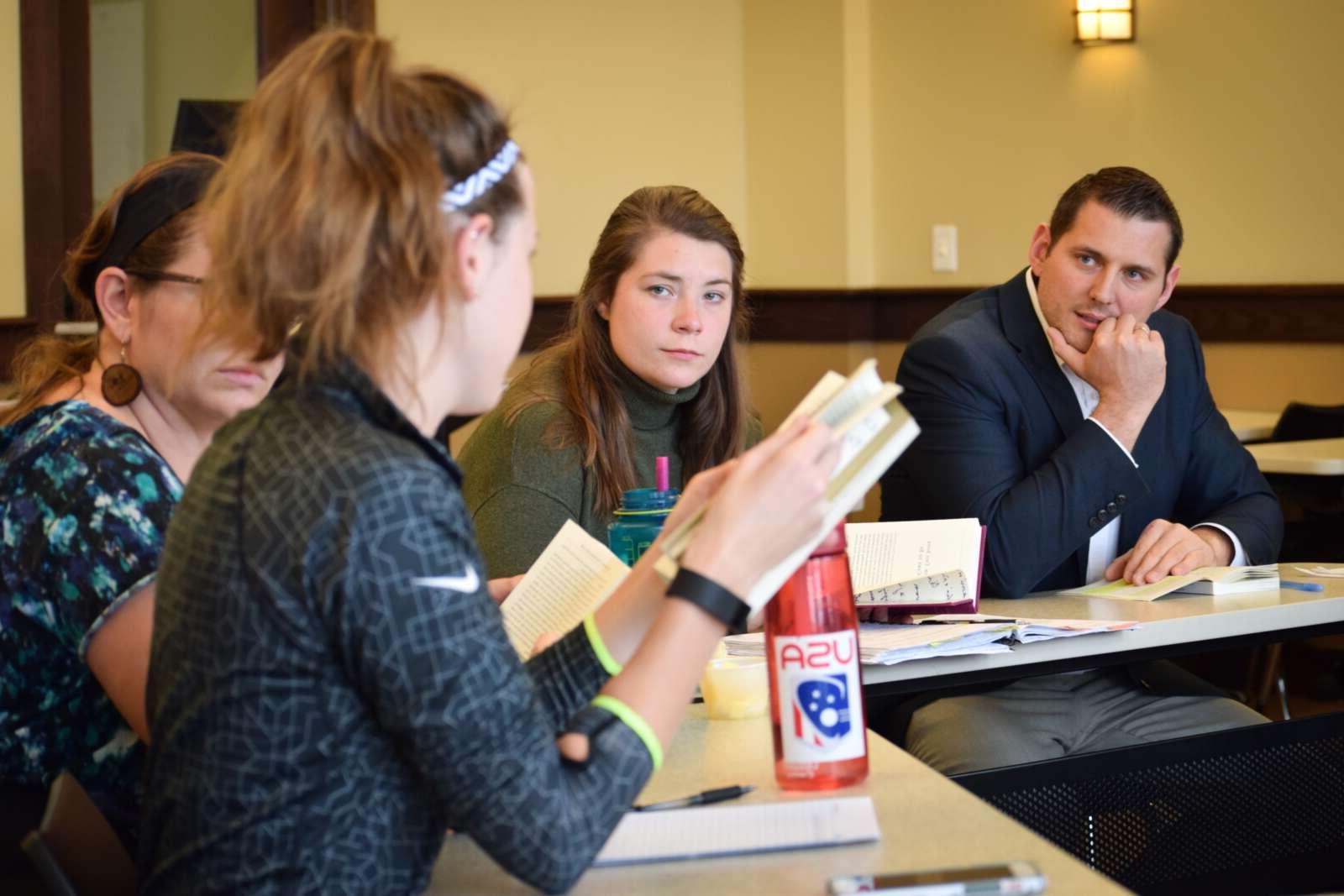 students and professor discussing readings in a circle